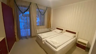 a small bedroom with two beds and a window at Червената Шапчица Апартамент Гранд Манастира in Pamporovo