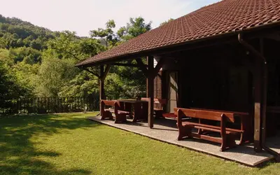 a gazebo with two benches and a grill at Boyana Vacation Houses in Cherni Vit