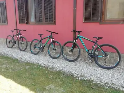 four bikes parked next to a pink building at Boyana Vacation Houses in Cherni Vit