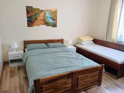 a bedroom with two beds and a painting on the wall at Villa Bella - A Rila Monastery Adventure in Kocherinovo