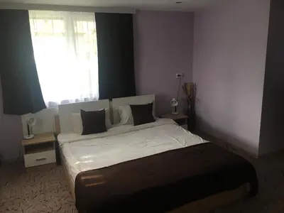 a bedroom with a bed with white sheets and a window at Къща ИВОНА in Sapareva Banya