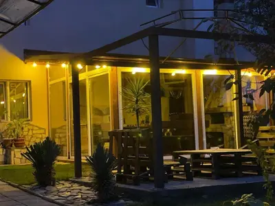 a patio with a picnic table and lights at night at Къща ИВОНА in Sapareva Banya