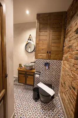 a bathroom with a toilet sitting on a tiled floor at NOMAD STUDIOS, Kapana in Plovdiv