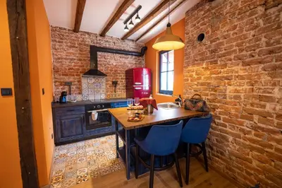 a kitchen with a wooden table and a brick wall at NOMAD STUDIOS, Kapana in Plovdiv