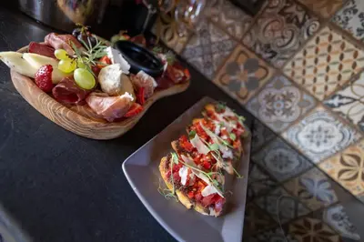 a table with a plate of pizza and a bowl of salad at NOMAD STUDIOS, Kapana in Plovdiv