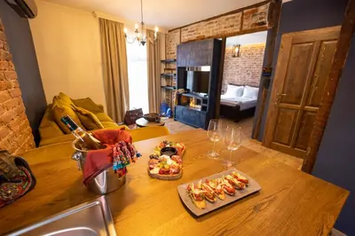 a kitchen counter with two plates of food and wine glasses at NOMAD STUDIOS, Kapana in Plovdiv