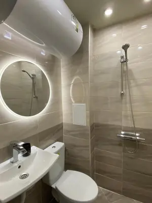 a bathroom with a toilet and a sink and a mirror at Brand new and modern apartment directly next to the metro station in Sofia