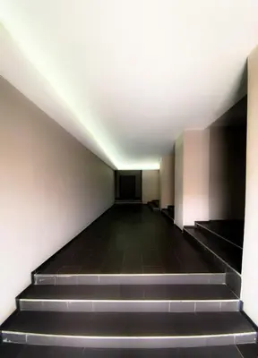 an empty hallway with stairs in a building at Brand new and modern apartment directly next to the metro station in Sofia