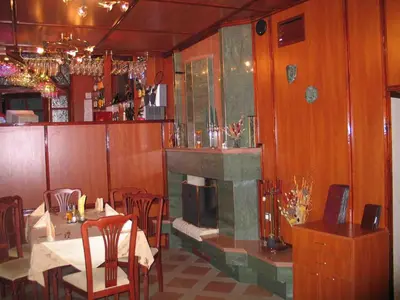 a restaurant with a fireplace and tables and chairs at Darling Hotel in Sofia