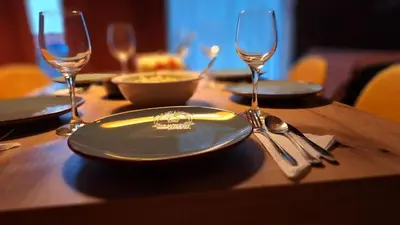 a wooden table with plates and wine glasses on it at Villa Carpe Diem in Pamporovo