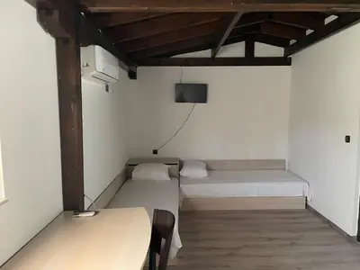 a small room with two beds and a table at Apart Uzunov-3 in Hisarya