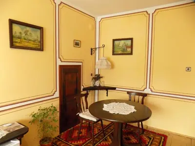 a table and chairs in a room with yellow walls at Dona Guest House - Horse Riding in Koprivshtitsa