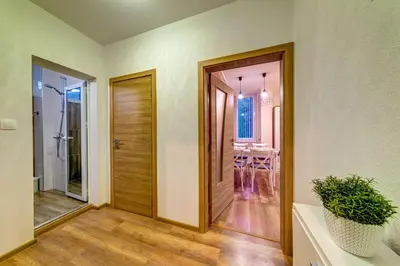 a hallway with a wooden door and a dining room at ИНвела in Smolyan