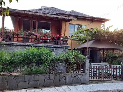 a house with flowers on the balcony of it at Апартаменти за гости ,,Тракия'' in Hisarya