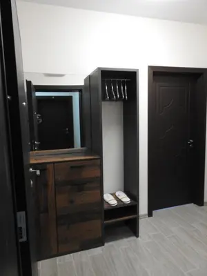 a room with a tv and a dresser and a door at Vintage Studio Mladost in Sofia