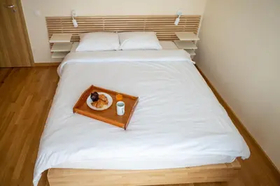 a bed with a tray with a plate of food on it at Modern and Spacious apartments in the City Centre in Sofia