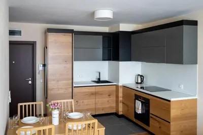 a kitchen with wooden cabinets and a table and chairs at Modern and Spacious apartments in the City Centre in Sofia