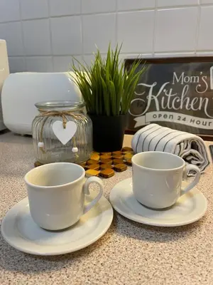 two white cups and saucers on a counter at Private Apartment Laplandia 77 (Pamporovo, Bulgaria) in Pamporovo