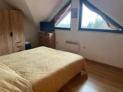 a bedroom with a bed and a large window at Private Apartment Laplandia 77 (Pamporovo, Bulgaria) in Pamporovo