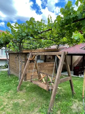 a picnic table with a swing under a tree at Св.Георги in Sapareva Banya
