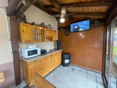 a kitchen with wooden cabinets and a microwave at Св.Георги in Sapareva Banya