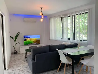 a living room with a couch and a table at Nordic Style Apartment with Parking place in Sofia