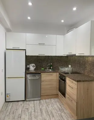 a kitchen with white appliances and wooden cabinets at Nordic Style Apartment with Parking place in Sofia