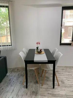 a black dining room table with white chairs at Nordic Style Apartment with Parking place in Sofia