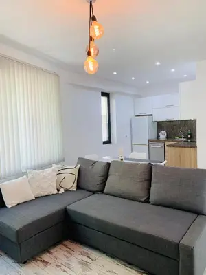 a living room with a couch and a kitchen at Nordic Style Apartment with Parking place in Sofia