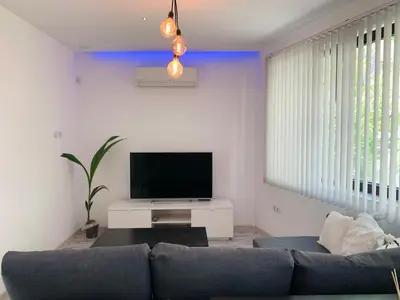 a living room with a couch and a flat screen tv at Nordic Style Apartment with Parking place in Sofia