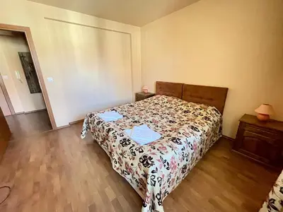 a bedroom with a bed with a comforter on it at Private Apartments next to Bellevue Residence in Bansko