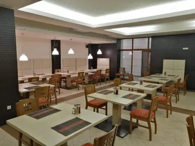 a dining room with tables and chairs in a restaurant at Private Apartments next to Bellevue Residence in Bansko