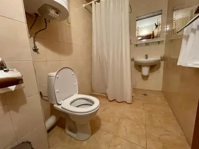 a bathroom with a toilet and a sink at Private Apartments next to Bellevue Residence in Bansko