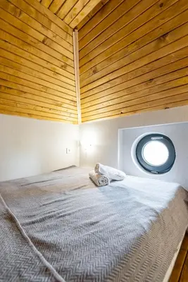 a bedroom with a large bed with a round window at Aurora Hills Hotel in Plovdiv