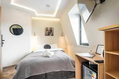 a small attic bedroom with a bed and a desk at Aurora Hills Hotel in Plovdiv