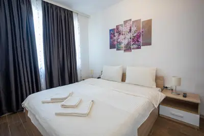 a bedroom with a white bed with two towels on it at Karastoyanovi's apartment 2 in Sofia