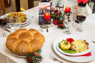 a table with plates of food and glasses of wine at Family Hotel Teteven in Teteven