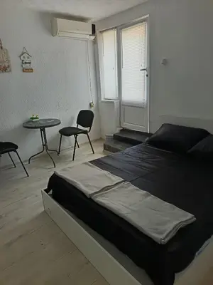 a bedroom with a bed and a table and chairs at The hiils 4 Plovdiv in Plovdiv