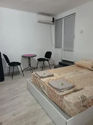a bedroom with a bed and two chairs and a table at The hiils 4 Plovdiv in Plovdiv