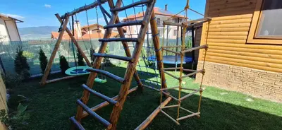 a wooden playground with a swing set in a yard at Вила ВлаиДа in Sapareva Banya