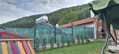 a fence in front of a house with a mountain at Вила ВлаиДа in Sapareva Banya