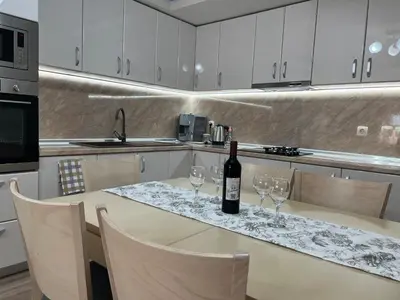 a bottle of wine sitting on a table in a kitchen at Къща за гости ТАТЯНА / GUEST HOUSE TATIANA in Petrich