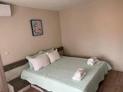 a bedroom with a bed with two slippers on it at Къща за гости ТАТЯНА / GUEST HOUSE TATIANA in Petrich