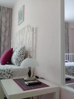 a bedroom with a bed and a table with a lamp at Sandanski Peak Guest Rooms in Sandanski