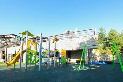 a playground with several slides and swings at Hotel Leshten in Leshten