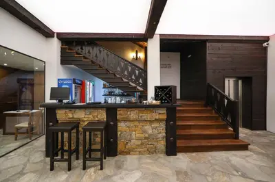 a bar in a building with a staircase at Hotel Leshten in Leshten