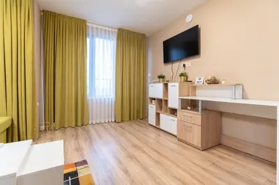 a living room with a television on the wall at City Central 1-Bed Apartments in Plovdiv