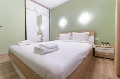 a bedroom with a large white bed with towels on it at City Central 1-Bed Apartments in Plovdiv
