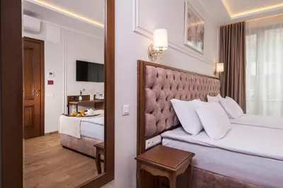 a hotel room with a bed and a mirror at Villa Flavia Heritage Boutique Hotel in Plovdiv