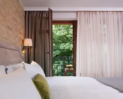 a bedroom with two white beds and a window at Villa Flavia Heritage Boutique Hotel in Plovdiv